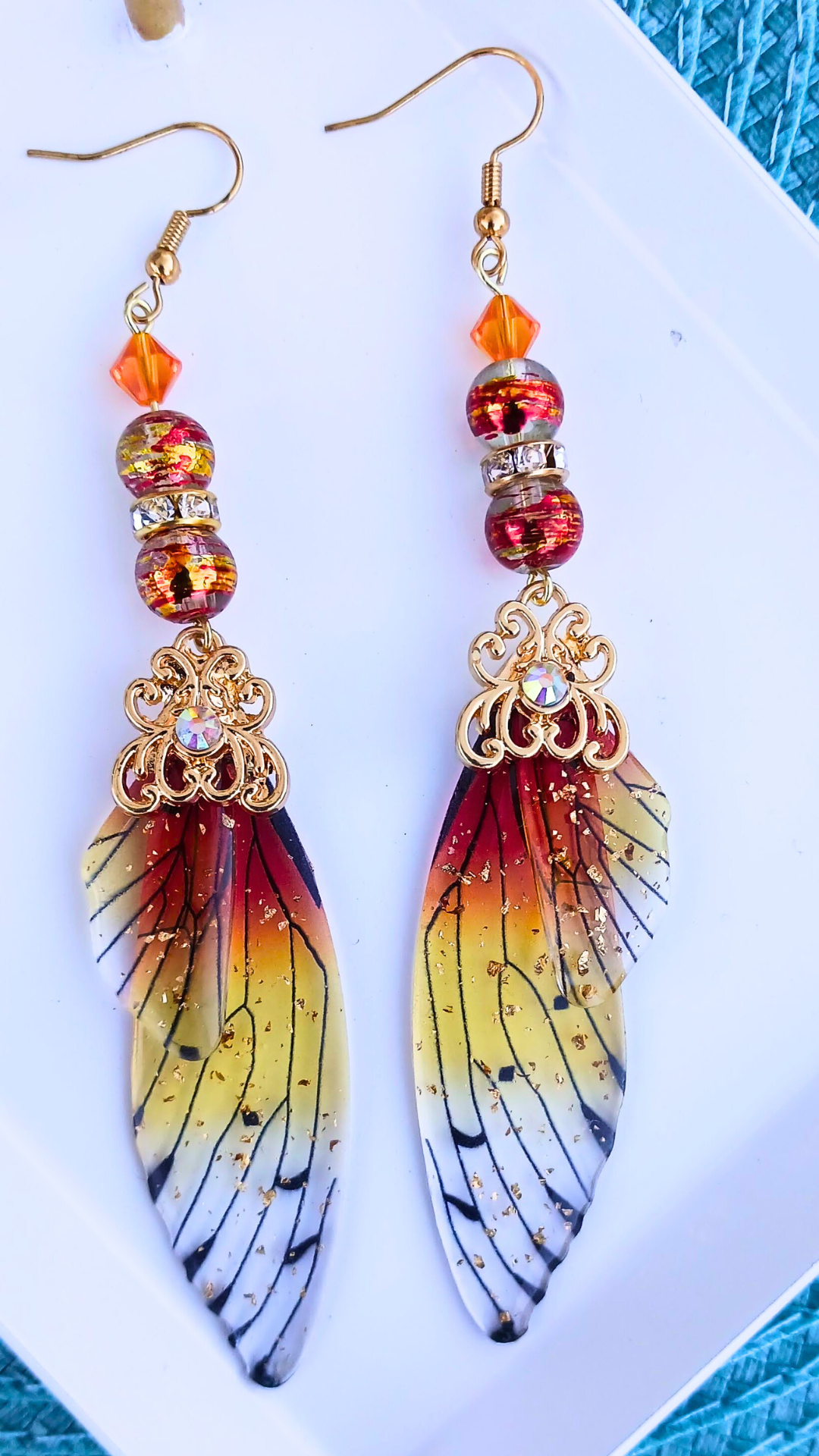 orange butterfly wing earrings flat lay